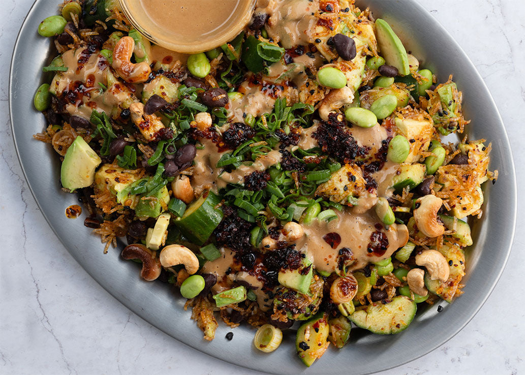 Crispy Rice Salad With Smacked Cucumber, Avocado, Edamame, Black Beans, Toasted Cashews, Chilli & Satay Dressing