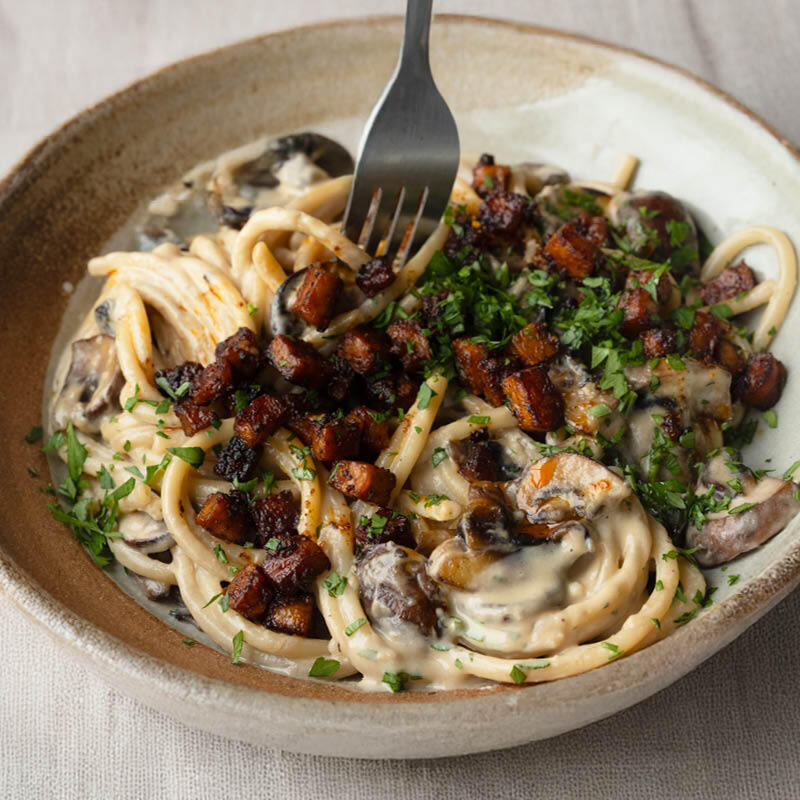 High Protein Creamy Garlic Bucatini With Chestnut Mushrooms, Crispy Tempeh 'Pancetta' & Fresh Parsley