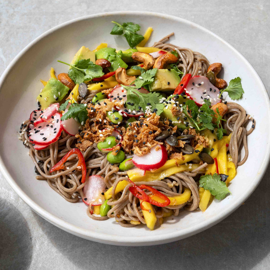 Mango Soba Noodle Salad With Avocado, Edamame, Cashews, Pickled Radish, Toasted Seeds & Crispy Onions