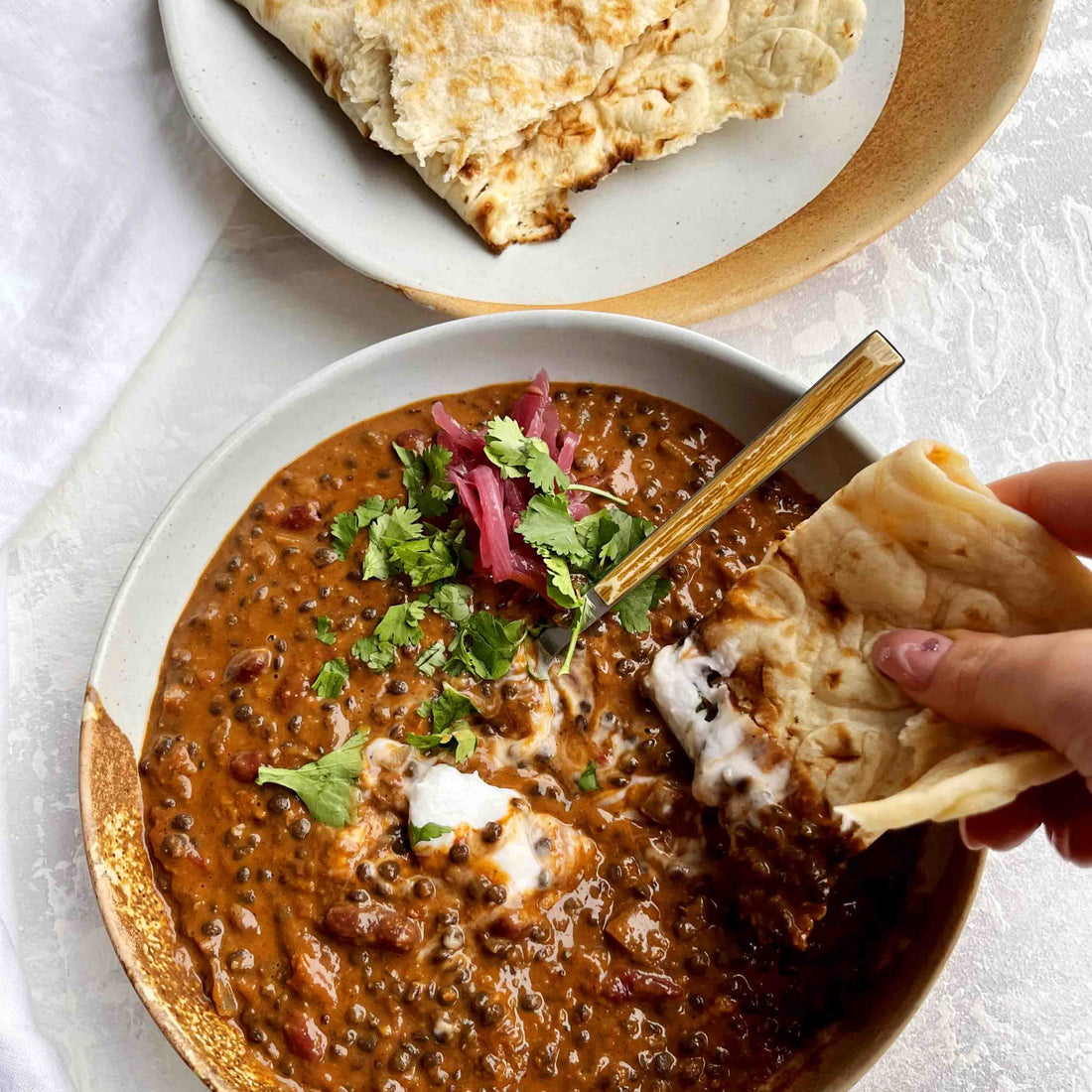 Rich & Luxurious Black Daal Makhani With Pickled Red Onion, Coconut Yoghurt, and Garlic & Herb Flatbread